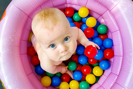Baby in ball pit. Adobe Stock photo 268103982.